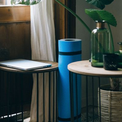 Minimalist yoga mat rolled out on a dark floor.